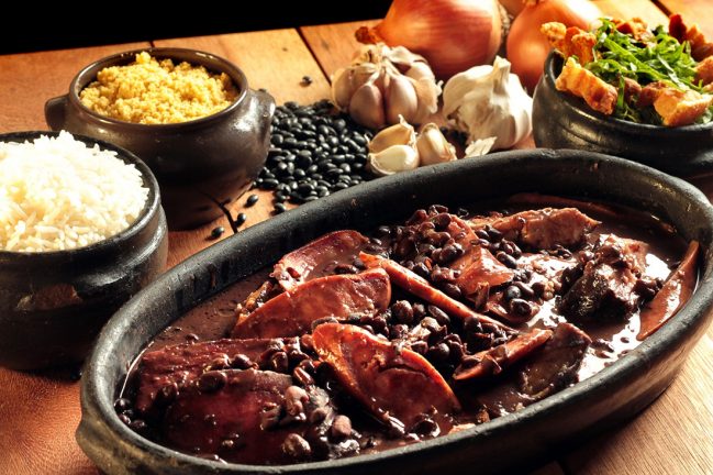 Comidas típicas de exemplo: feijoada, arroz e farofa.